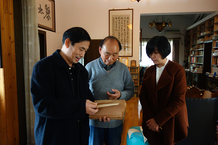 中国书店出版社于华刚社长（左1）与唐中六先生（中）、李佳女士（右1）在鉴赏古琴谱